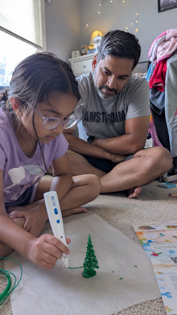 A child enjoying the Pen'Up 3D pen at the craft table