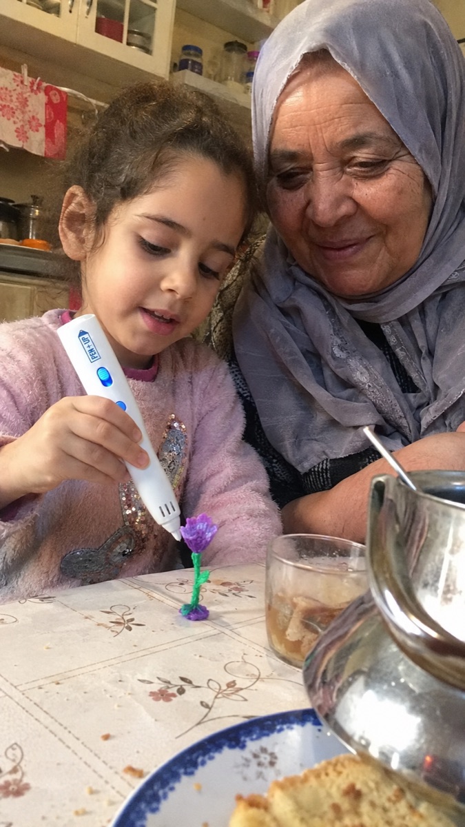 A child holds the Pen'Up 3D pen and one of their creations