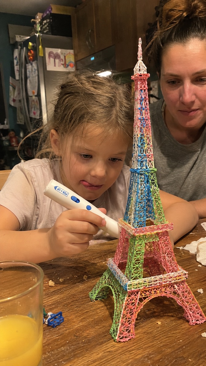 A focused child creating a 3D shape with the Pen'Up 3D pen